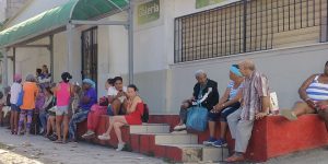 Cubanos esperan en las afueras de una tienda para comprar alimentos